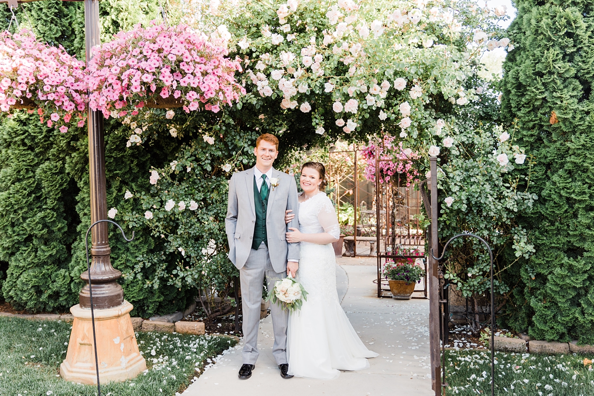 Utah summer wedding photography at Le Jardin and the Jordan River Temple, bride and groom with flower arch