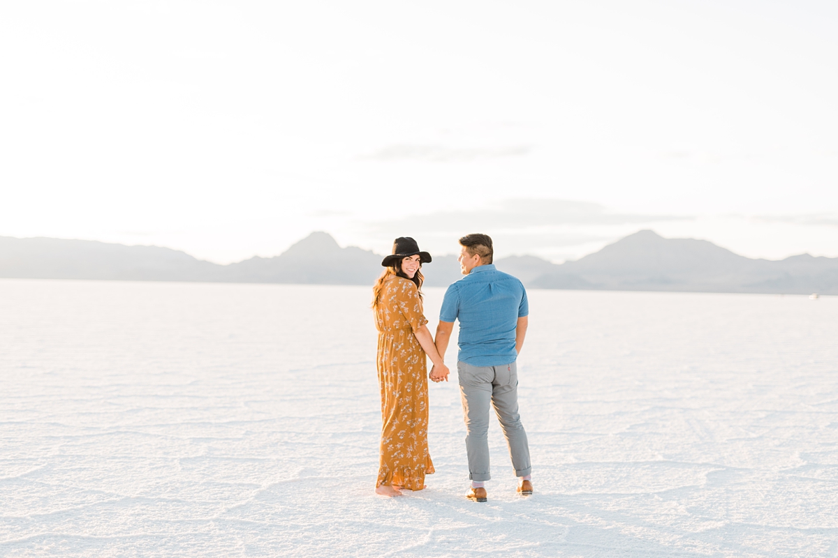 engagement photos at Bonneville Salt Flats Utah engagement photography, yellow dress blue shirt summer outfits, what to wear for engagement photos, road trip questions for couples